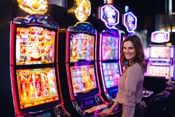 A woman smiling by bright slot machines showing lucky symbols, showcasing the exciting slot offerings at 1111BED.