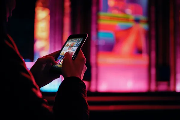 A person using their device against a moody casino-themed background, illustrating the smooth re-entry process at 1111BED.